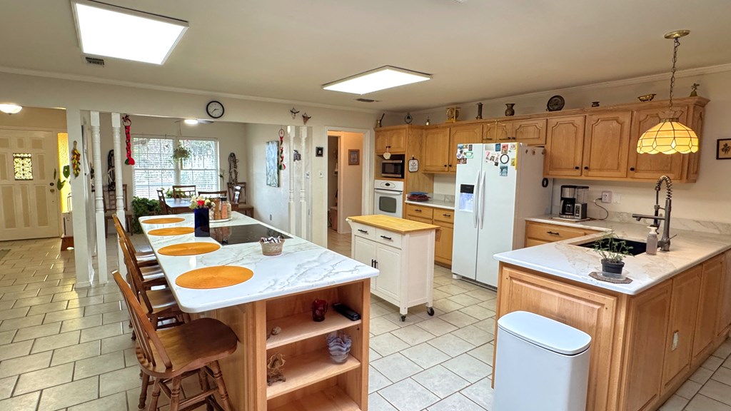 305 Rock Ridge Kerrville, TX 78028 - Photo 9 of 36 a kitchen with refrigerator a stove a dining table and chairs with wooden floor