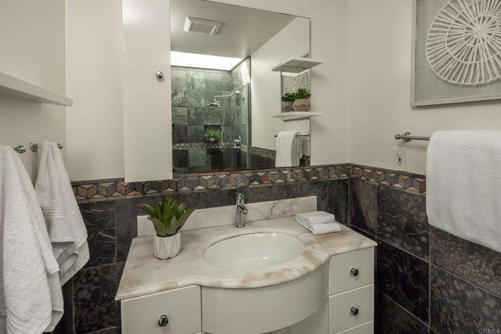 5416 Taft Avenue La Jolla, CA 92037 - Photo 11 of 23 a bathroom with a granite countertop sink and a mirror