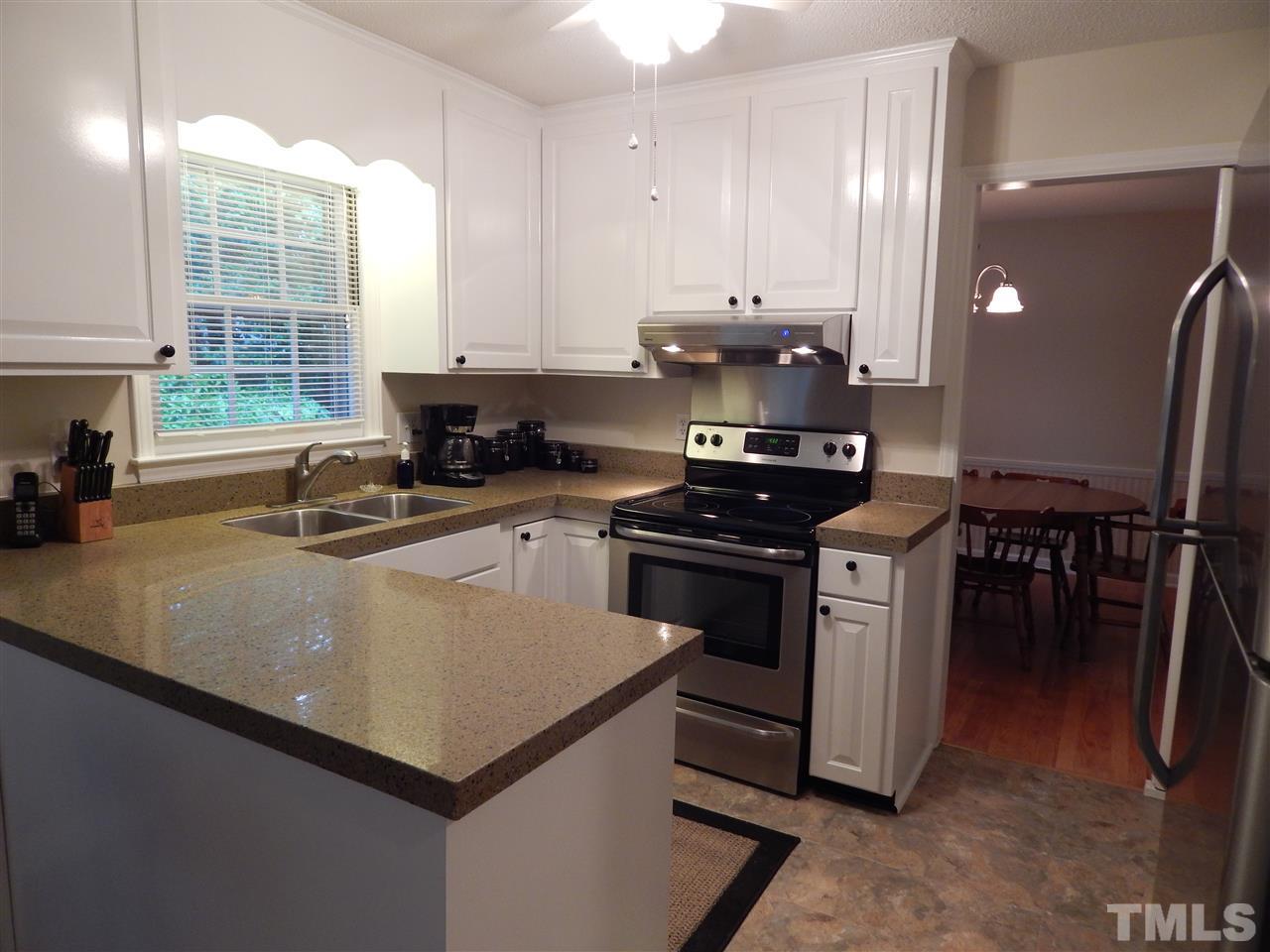 5304 Edgewood Road Raleigh, NC 27609 - Photo 5 of 25 a kitchen with stainless steel appliances a sink a stove a refrigerator cabinets and a counter top space