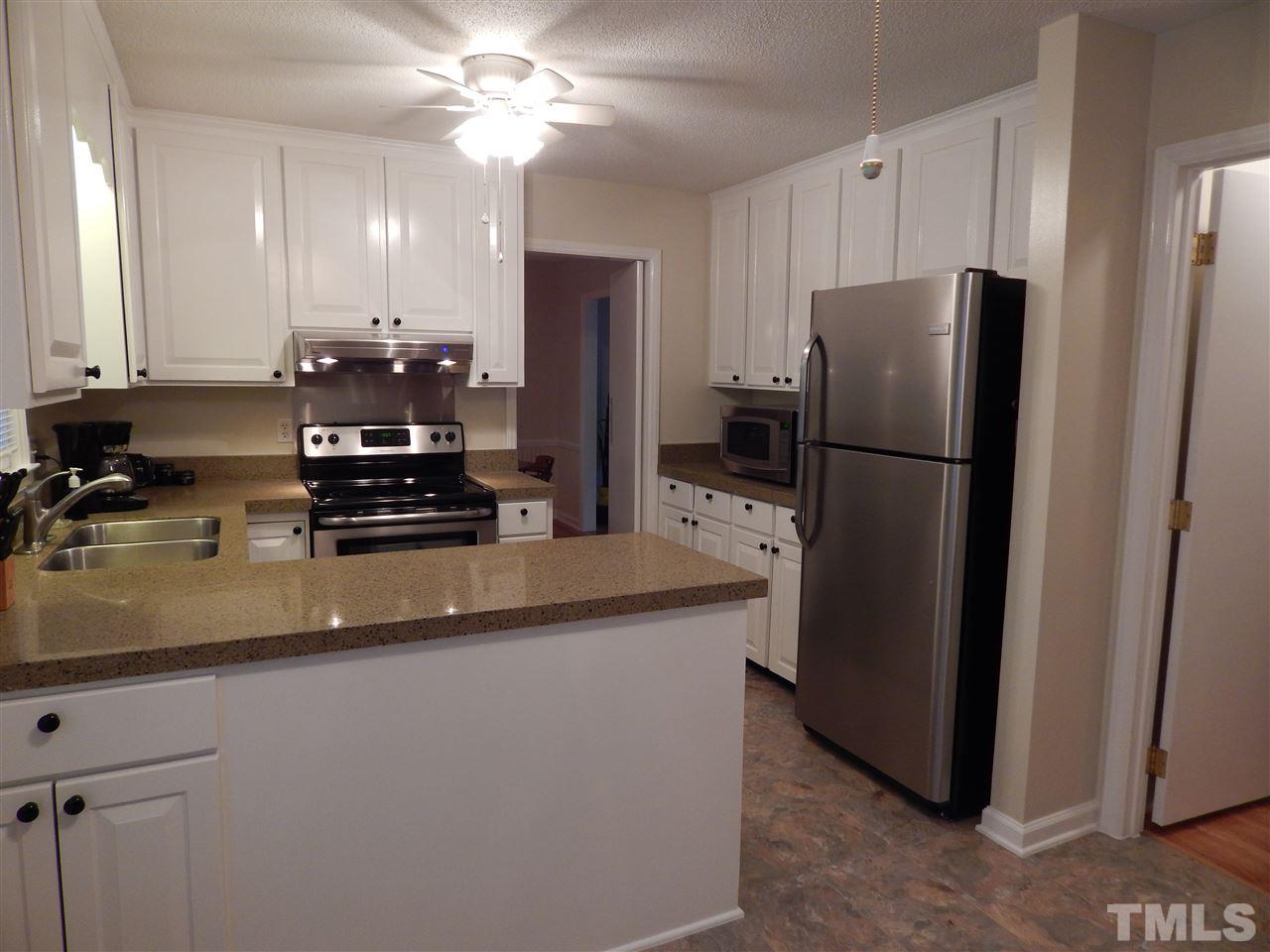 5304 Edgewood Road Raleigh, NC 27609 - Photo 7 of 25 a kitchen with a refrigerator a stove a sink and cabinets