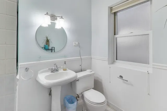 a bathroom with a sink toilet and mirror