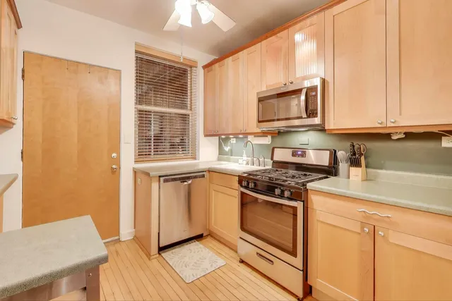 a kitchen with stainless steel appliances granite countertop a stove a sink and a microwave