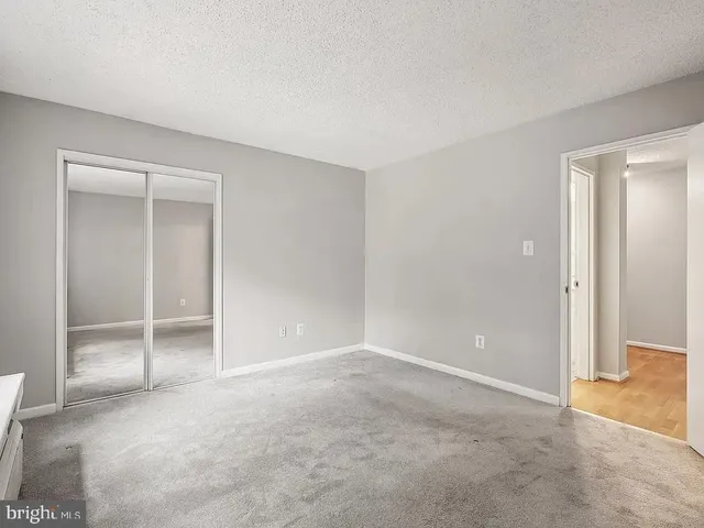 an empty room with closet and a window