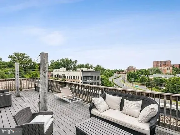 a view of a balcony with wooden floor and outdoor seating