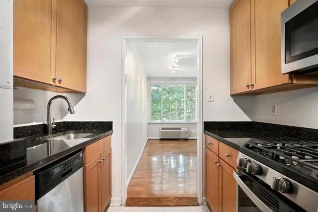 a kitchen with granite countertop a sink stove and cabinets