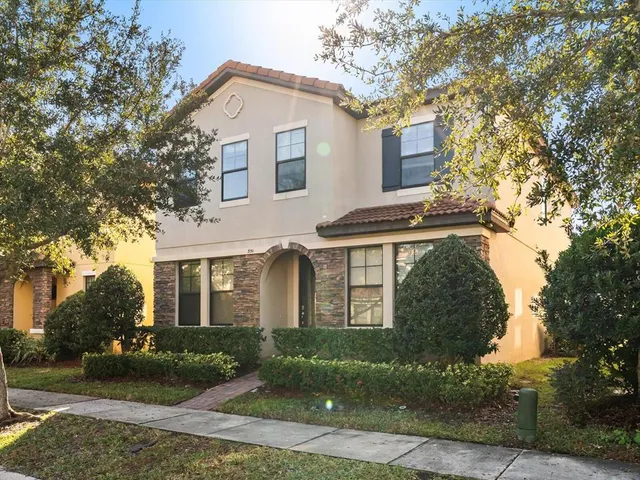 a front view of a house with a yard and potted plants