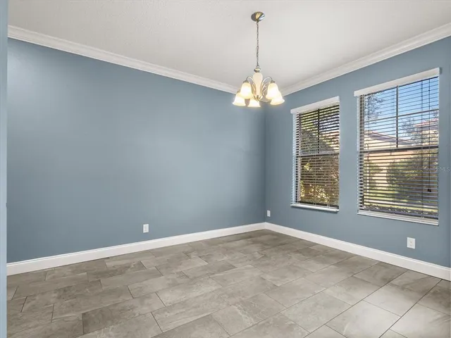 a view of a livingroom with a chandelier fan and windows