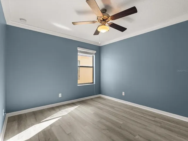 an empty room with a window and a fan
