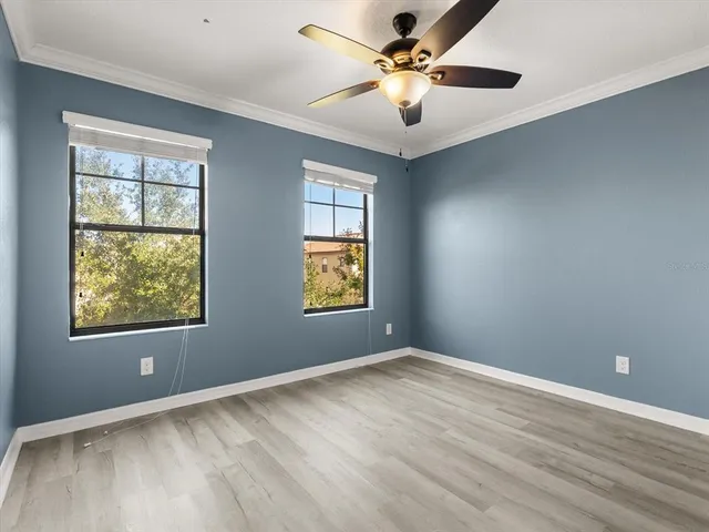 an empty room with windows and fan