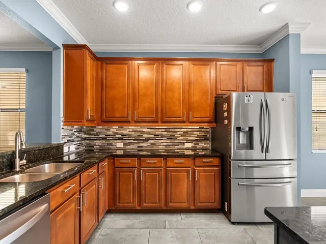 a kitchen with stainless steel appliances granite countertop a refrigerator and a sink
