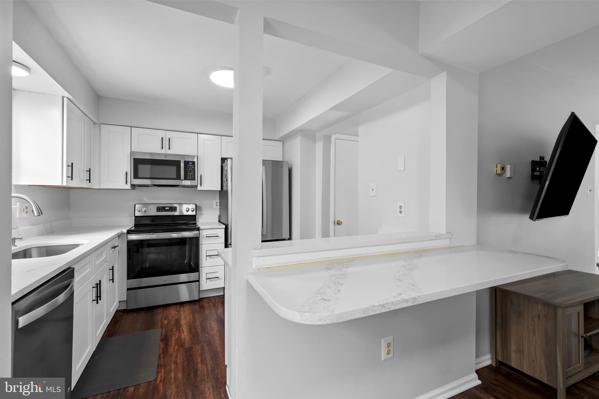 4511 Jenner Court Olney, MD 20832 - Photo 11 of 40 a kitchen with granite countertop a sink stove and microwave