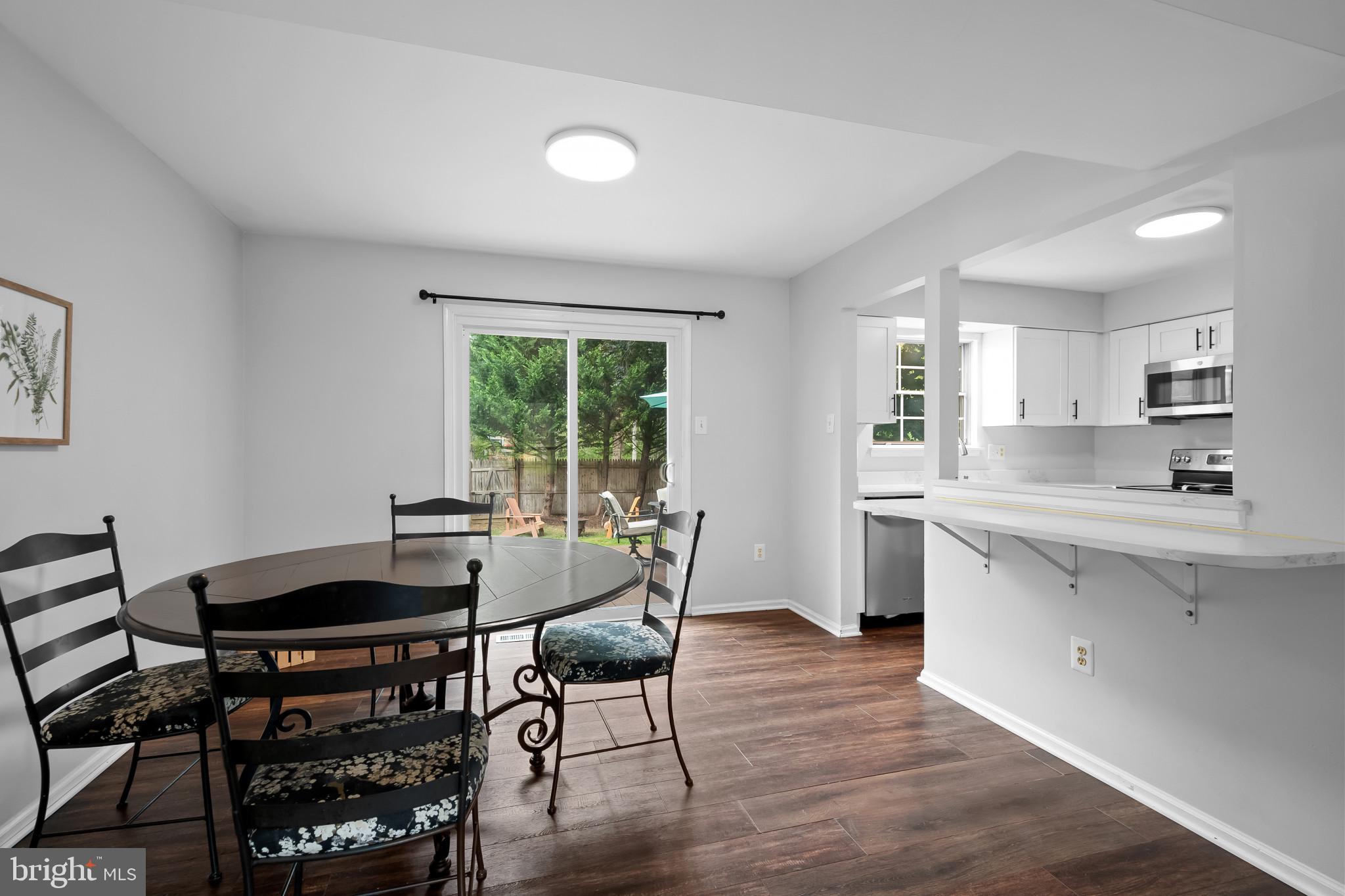 4511 Jenner Court Olney, MD 20832 - Photo 8 of 40 a kitchen with granite countertop a table chairs stove a sink dishwasher and cabinets