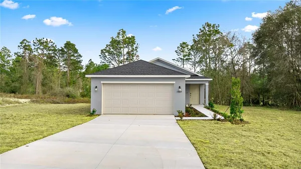 a view of a house with backyard and trees