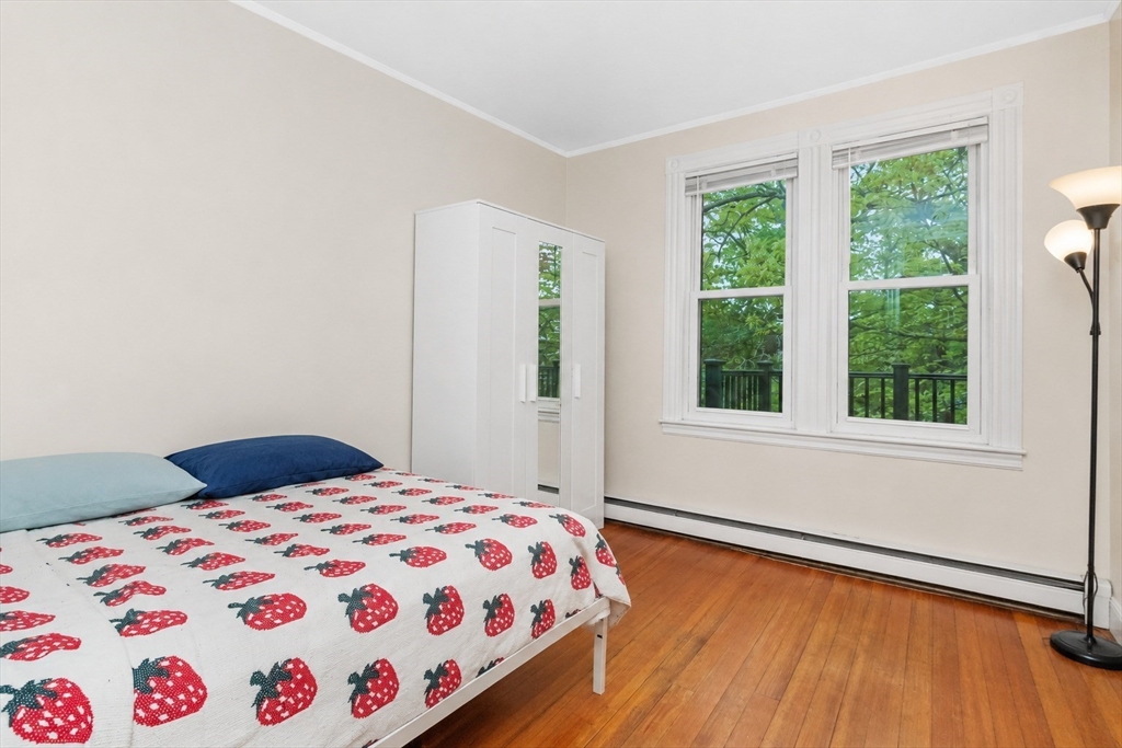8 Colliston Road Boston, MA 02135 - Photo 6 of 40 a bedroom with a bed and wooden floor