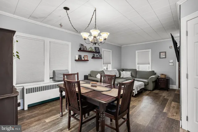 a view of a dining room with furniture wooden floor and chandelier
