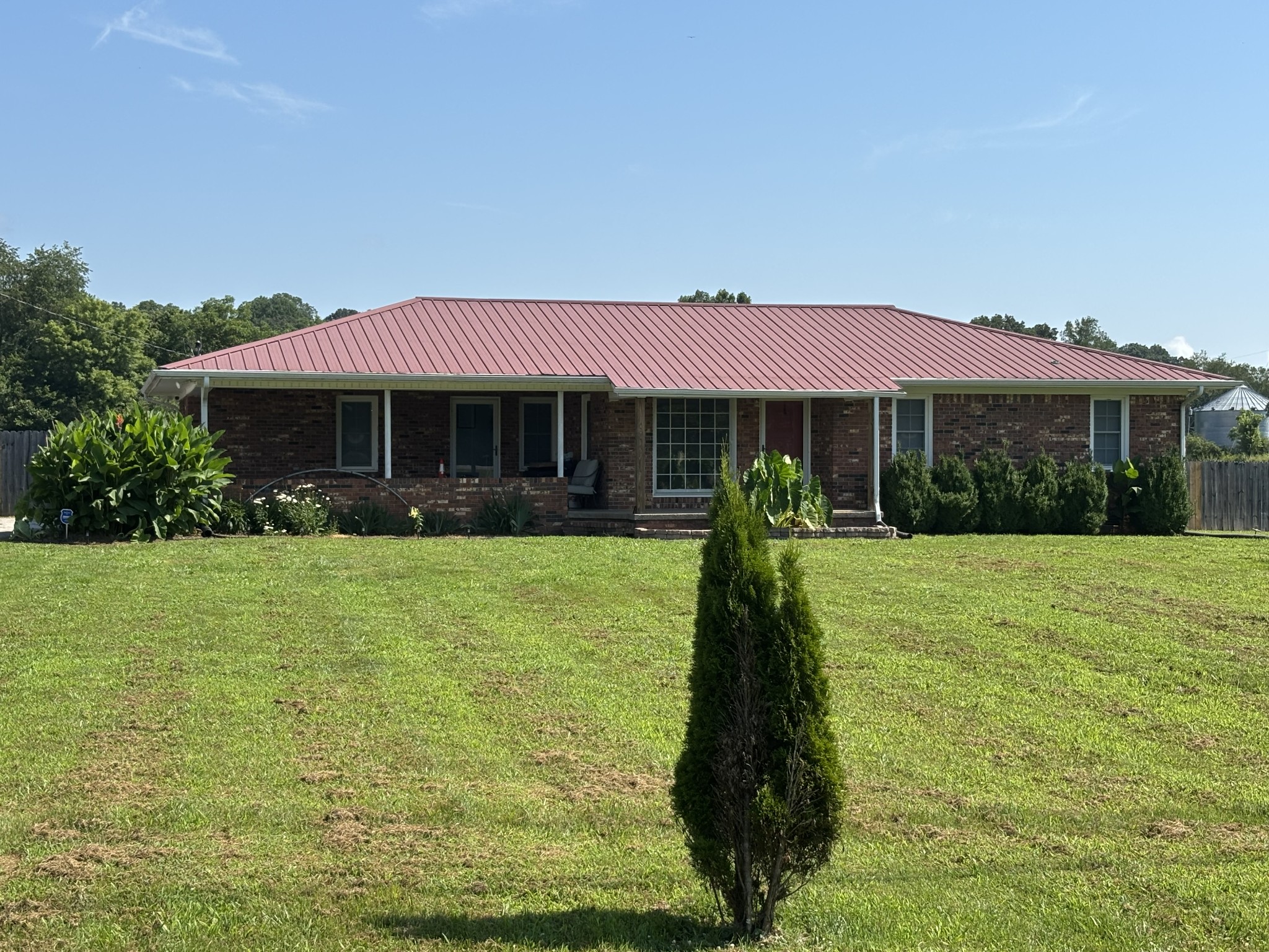 a front view of a house with a garden and trees