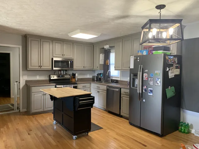 a kitchen with stainless steel appliances granite countertop a refrigerator stove and sink