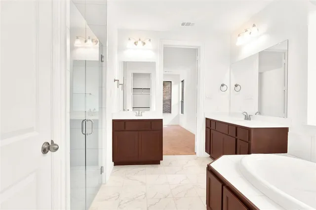 a spacious bathroom with a tub sink and mirror