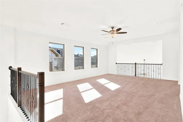 a view of a bedroom with wooden floor and a ceiling fan