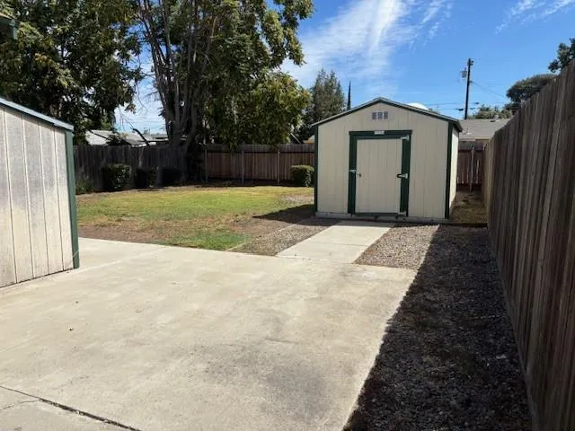 a view of a house with backyard and trees