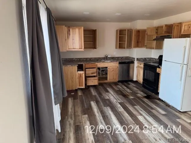 a kitchen with a refrigerator and white cabinets