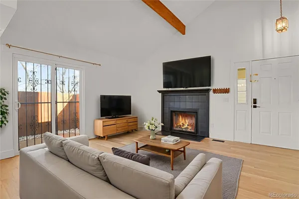 a living room with furniture a flat screen tv and a fireplace