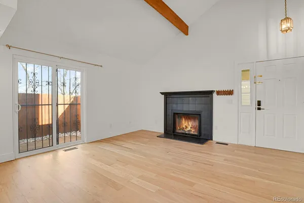 a view of an empty room with a window and fire place