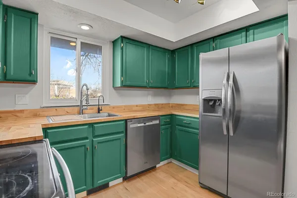 a kitchen with stainless steel appliances granite countertop a refrigerator and a sink