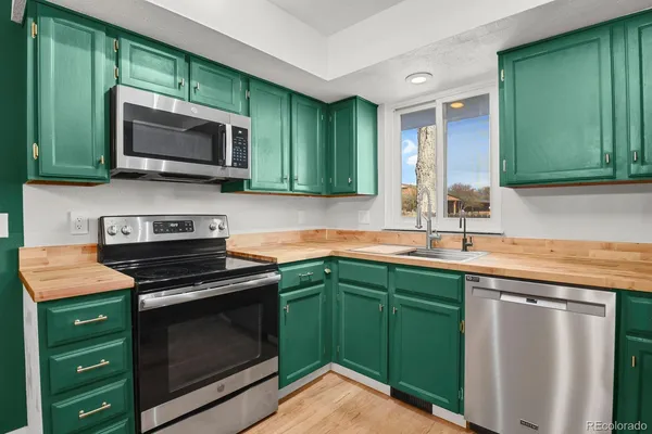 a kitchen with sink a microwave and cabinets