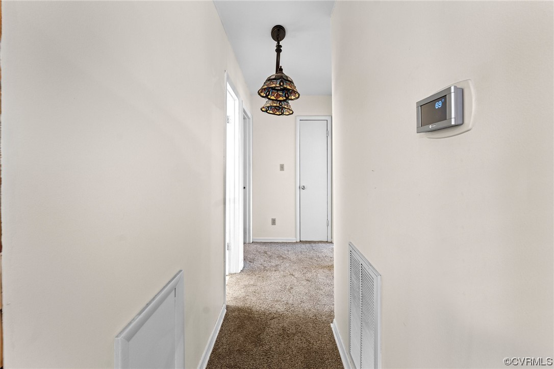 10083 Burkes Pond Road North, VA 23128 - Photo 15 of 36 a view of a hallway with a chandelier