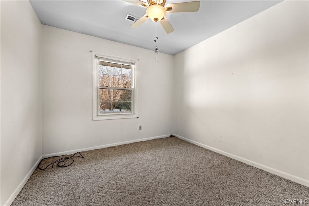 10083 Burkes Pond Road North, VA 23128 - Photo 17 of 36 an empty room with a window and a ceiling fan