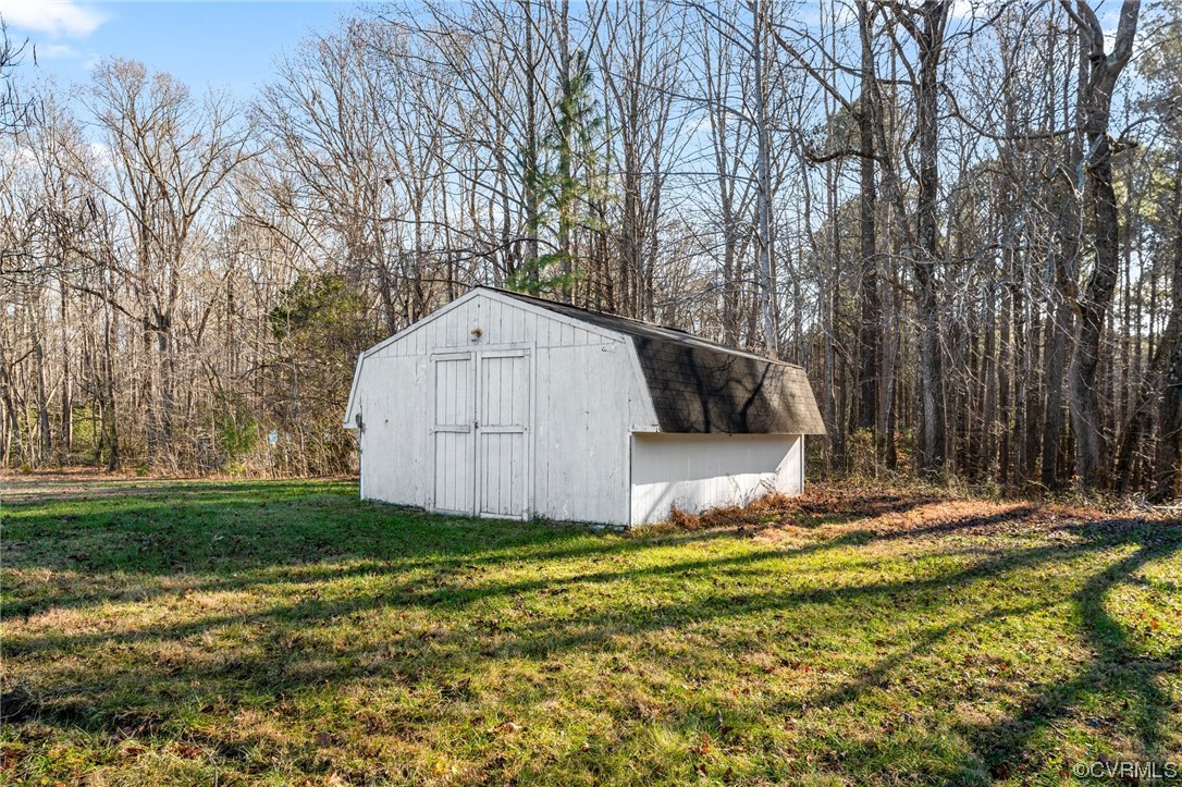 10083 Burkes Pond Road North, VA 23128 - Photo 31 of 36 a view of a tiny house with backyard and trees