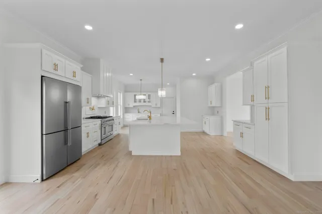 a large kitchen with a wooden floor and stainless steel appliances