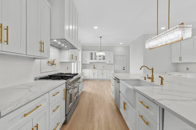 a kitchen with granite countertop a sink stove and cabinets