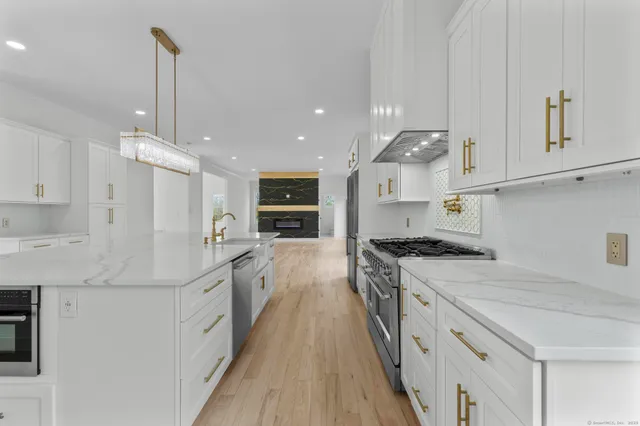 a kitchen with stainless steel appliances granite countertop a sink stove and refrigerator