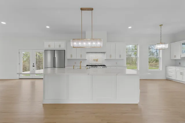 a view of kitchen with kitchen island stainless steel appliances sink cabinets and stove