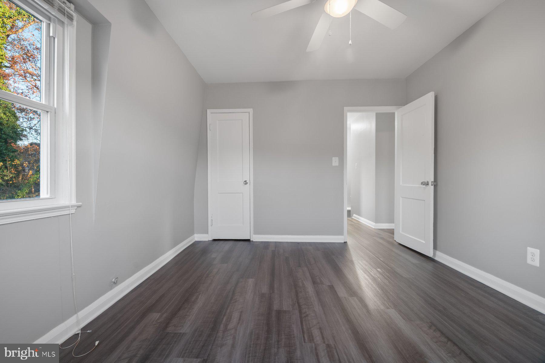 2909 Lawina Road Baltimore, MD 21216 - Photo 10 of 24 an empty room with wooden floor and windows