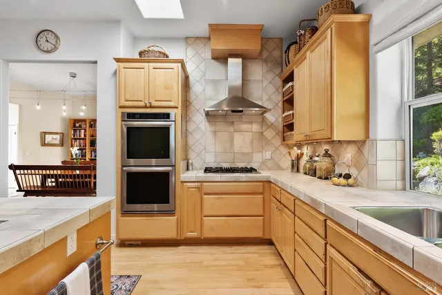 a kitchen with stainless steel appliances granite countertop a sink a stove and a refrigerator