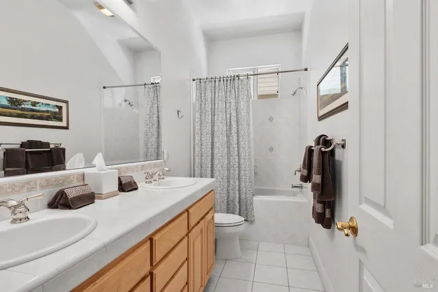 a bathroom with a double vanity sink a toilet and a mirror