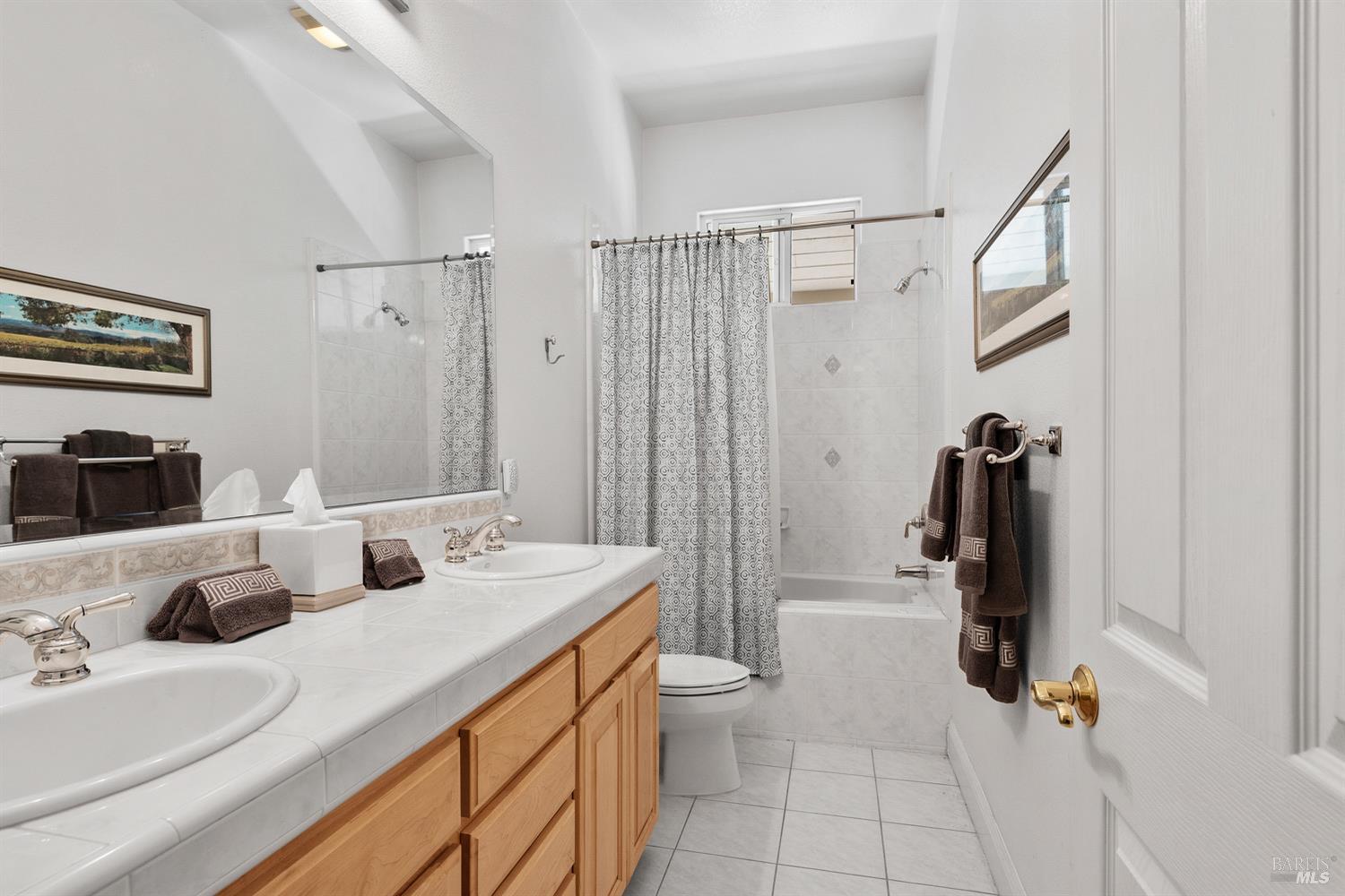 1885 Los Olivos Road Santa Rosa, CA 95404 - Photo 28 of 47 a bathroom with a double vanity sink a toilet and a mirror