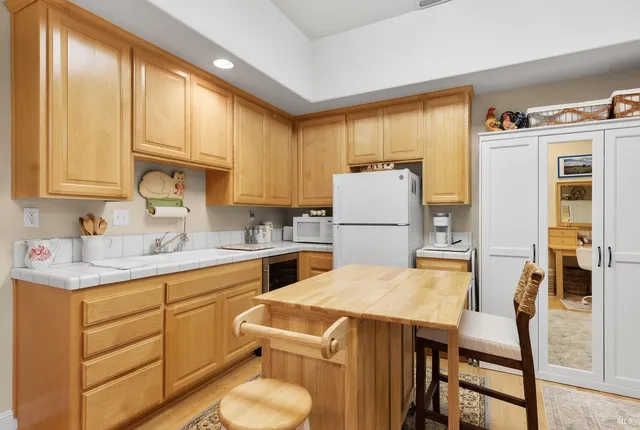 a kitchen with a refrigerator a stove a sink dishwasher and white cabinets with wooden floor