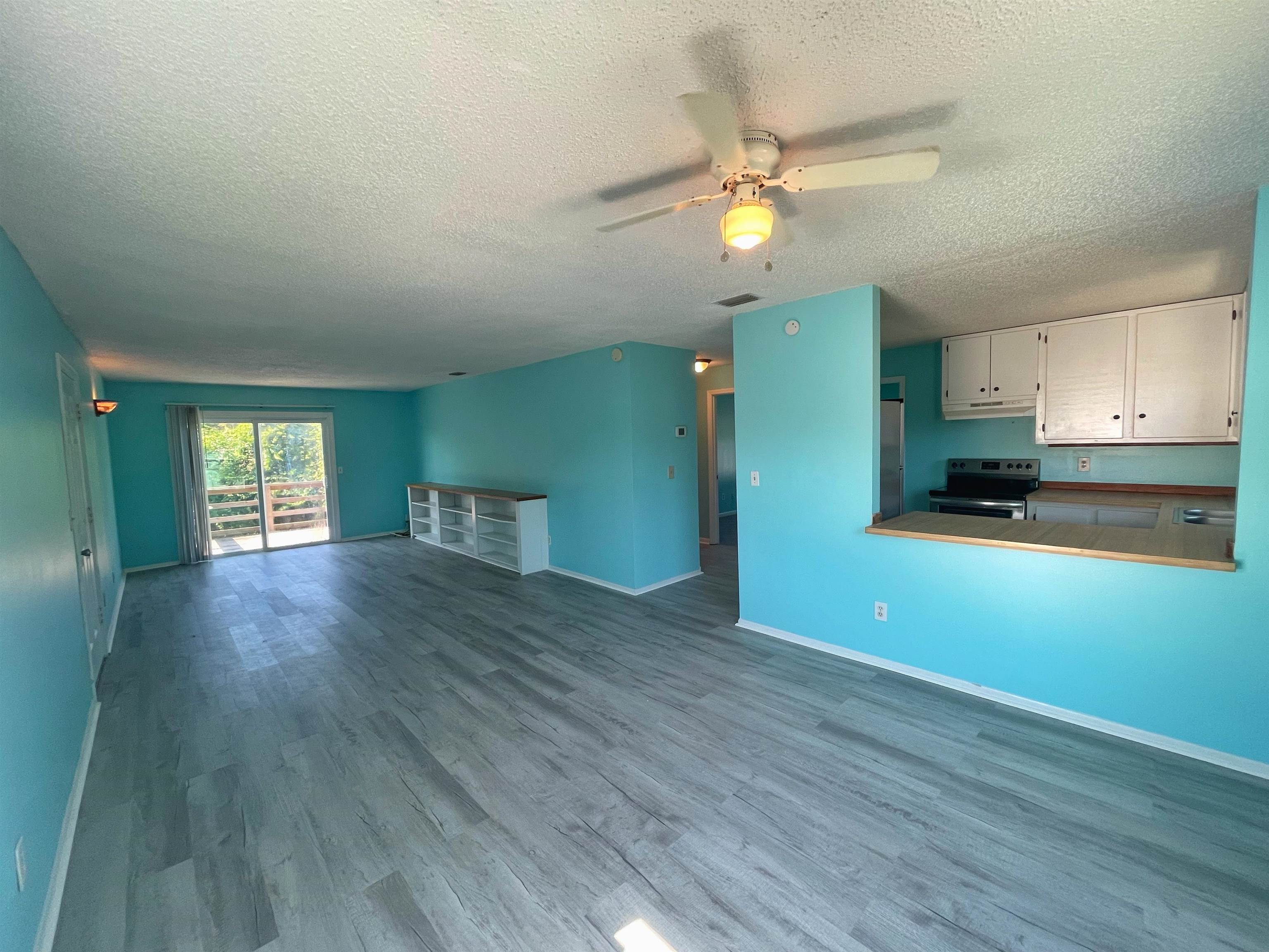 203 9th Street, Unit B St. Augustine, FL 32080 - Photo 2 of 16 a view of empty room with wooden floor and fan