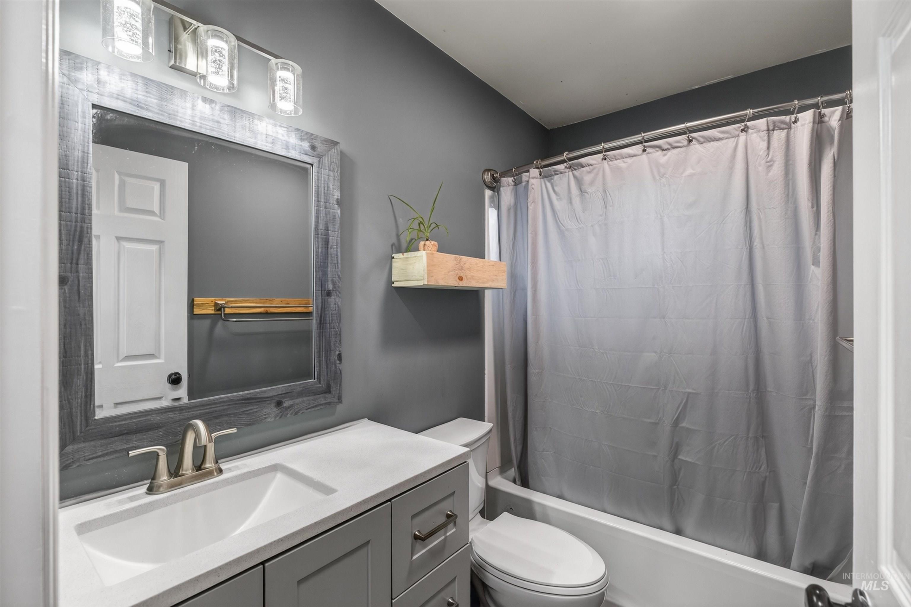 247 North Beech Street Genesee, ID 83832 - Photo 15 of 27 Bathroom featuring a light gray vanity with brushed nickel hardware, a white integrated sink, and a framed mirror
