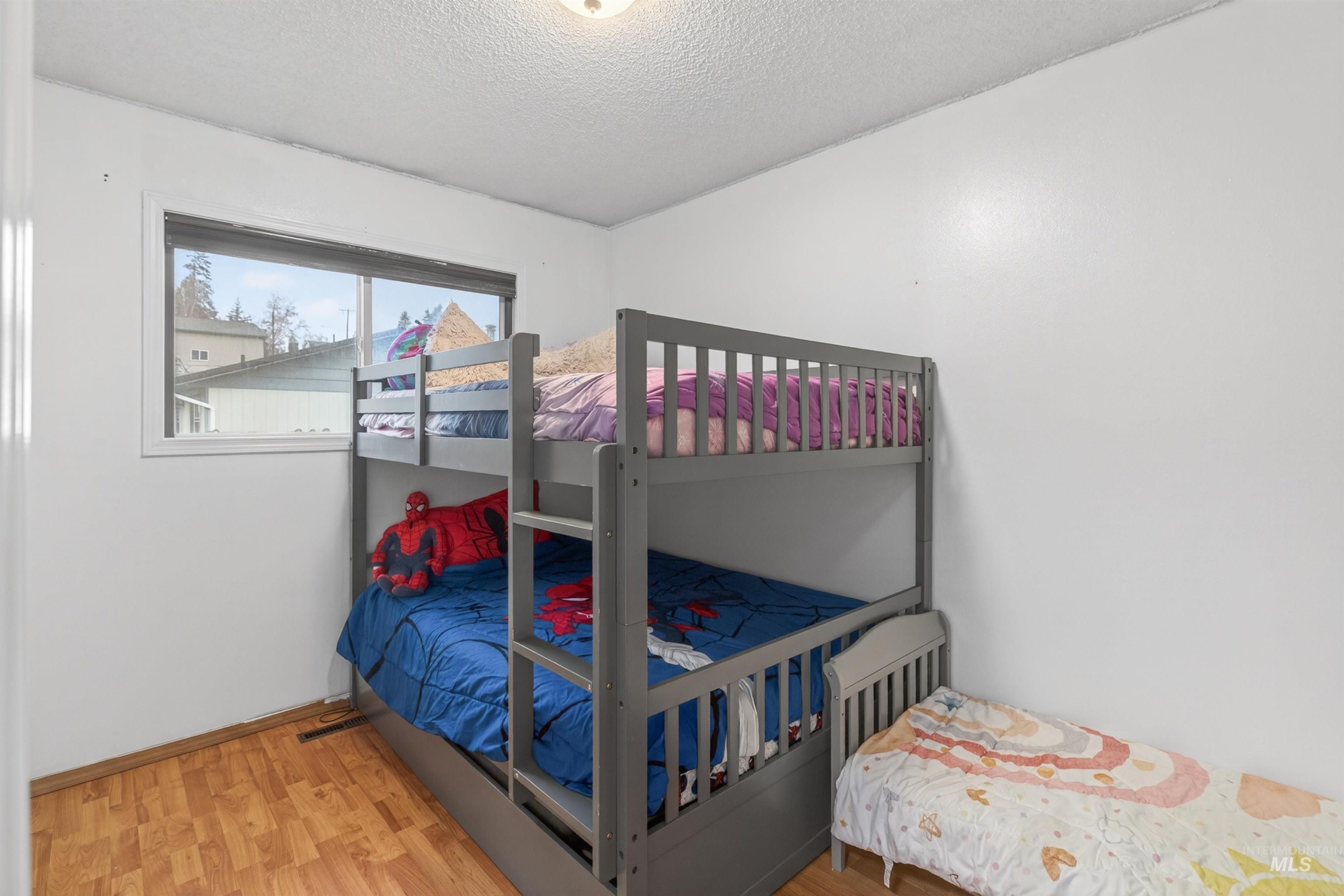 247 North Beech Street Genesee, ID 83832 - Photo 16 of 27 Bedroom featuring light wood-finish flooring, white painted walls, and a single window with white trim