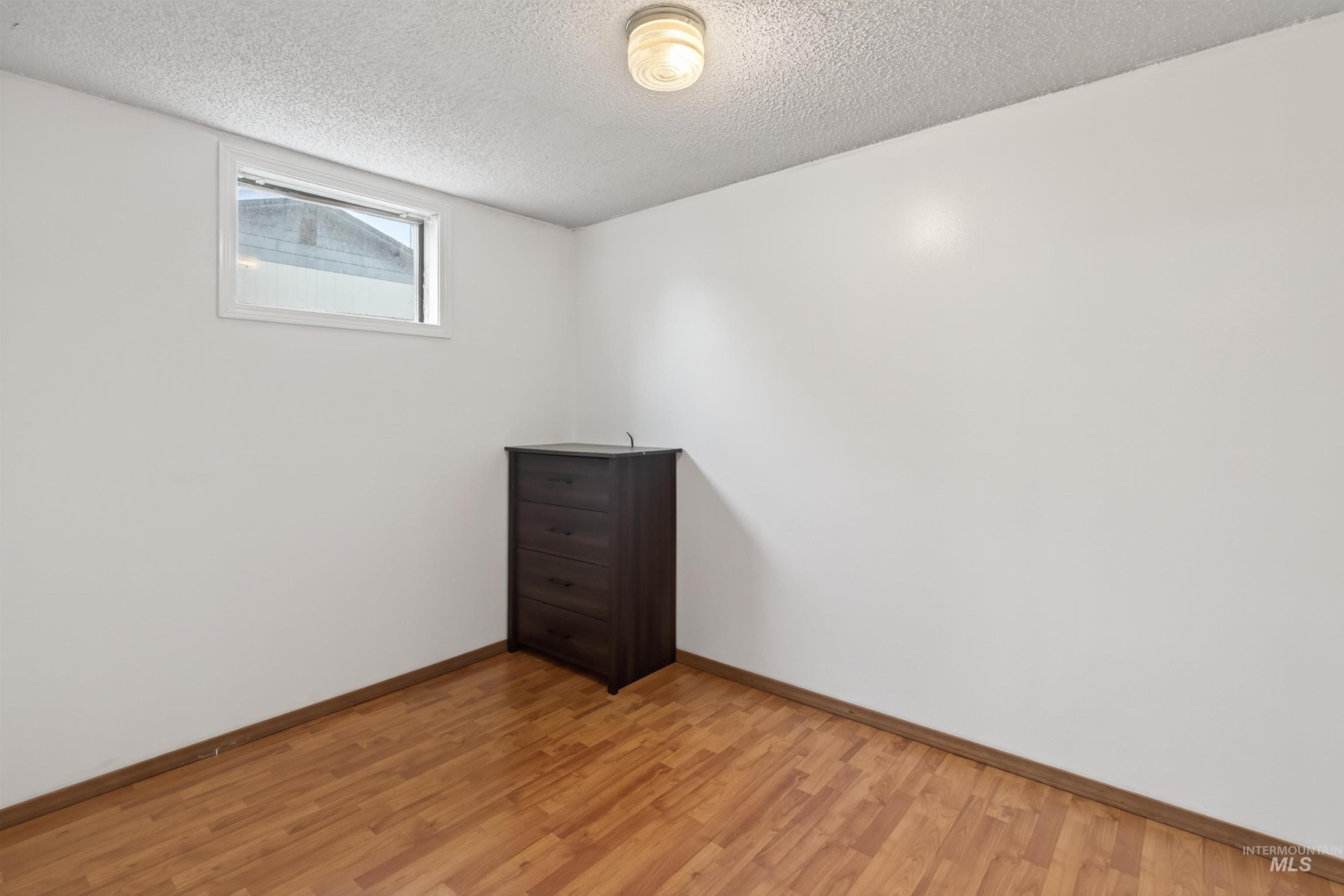 247 North Beech Street Genesee, ID 83832 - Photo 18 of 27 Bright room with wood-finish flooring, white walls, and a single window
