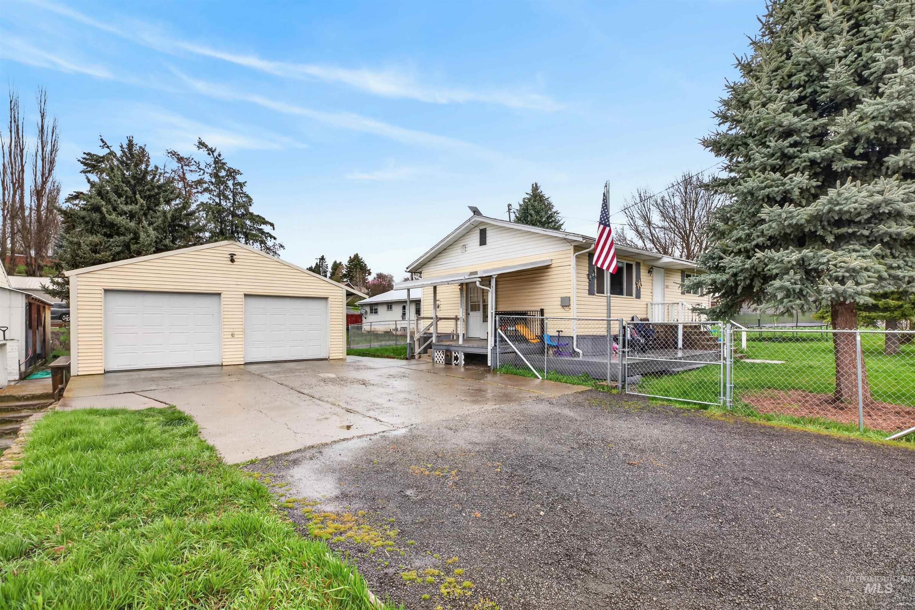 247 North Beech Street Genesee, ID 83832 - Photo 2 of 27 Detached two-car garage with horizontal siding and two white garage doors