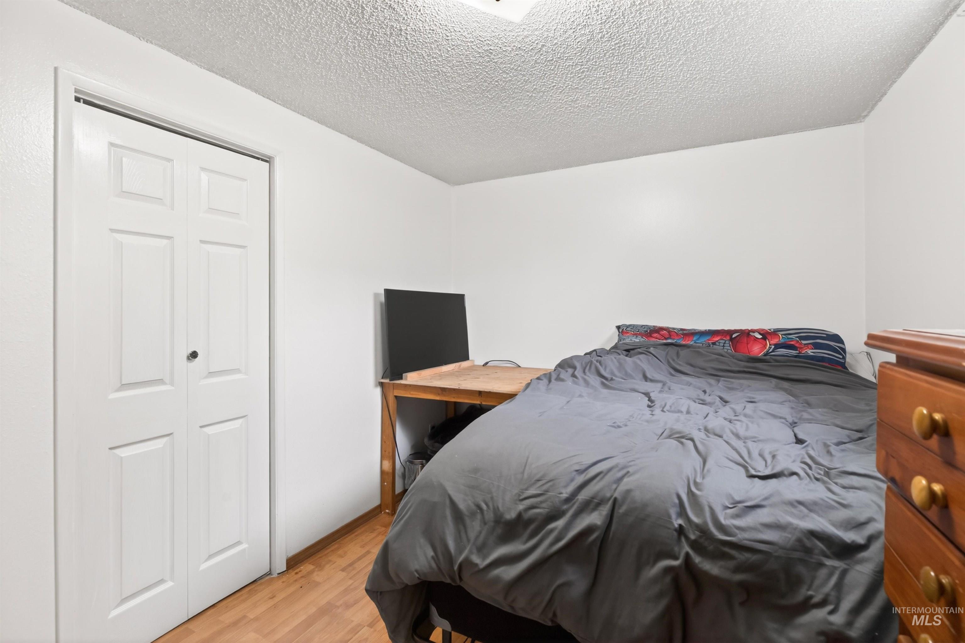 247 North Beech Street Genesee, ID 83832 - Photo 21 of 27 Room featuring wood-finish flooring, white walls, and a textured ceiling