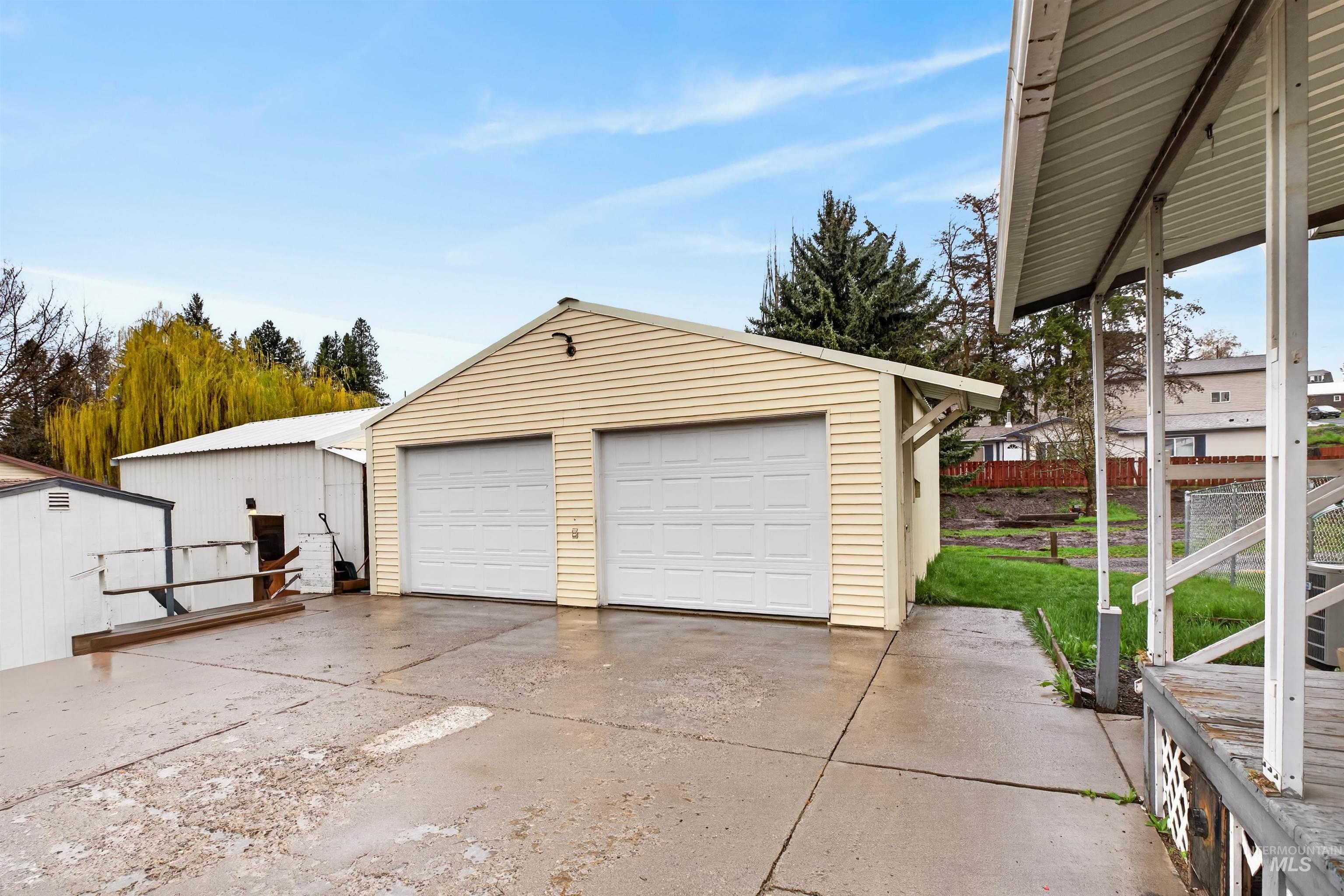 247 North Beech Street Genesee, ID 83832 - Photo 4 of 27 Detached two-car garage with horizontal siding, two white paneled garage doors, and a concrete driveway