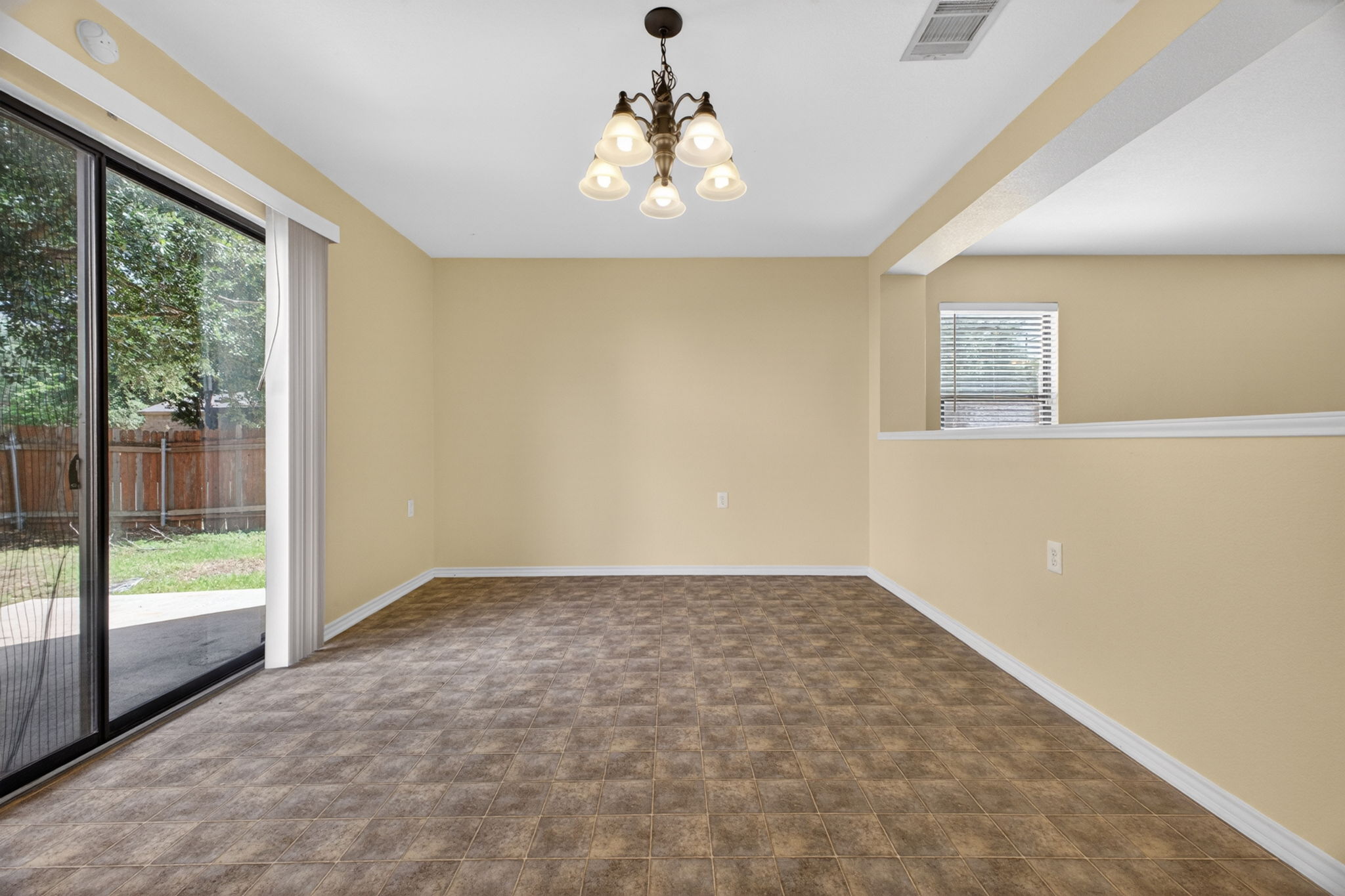 8813 Wiley Way Austin, TX 78747 - Photo 12 of 39 A classic chandelier illuminates this spacious room with sliding glass doors opening to a private yard.