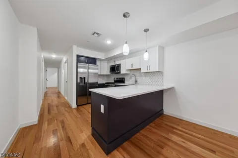 a view of kitchen with sink and wooden floor